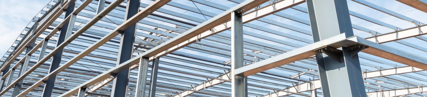 steel frame workshop is under construction against a blue sky - Construction Services